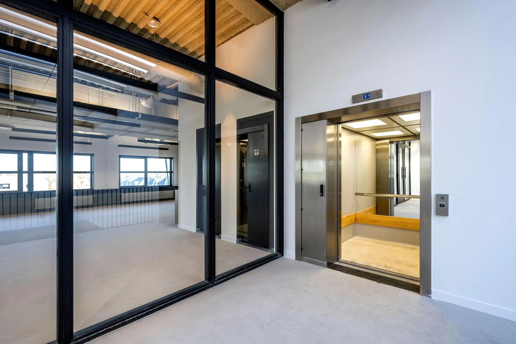 Moderne, lichte kantoorruimte aan de Singaporestraat met een open lift op de derde verdieping.