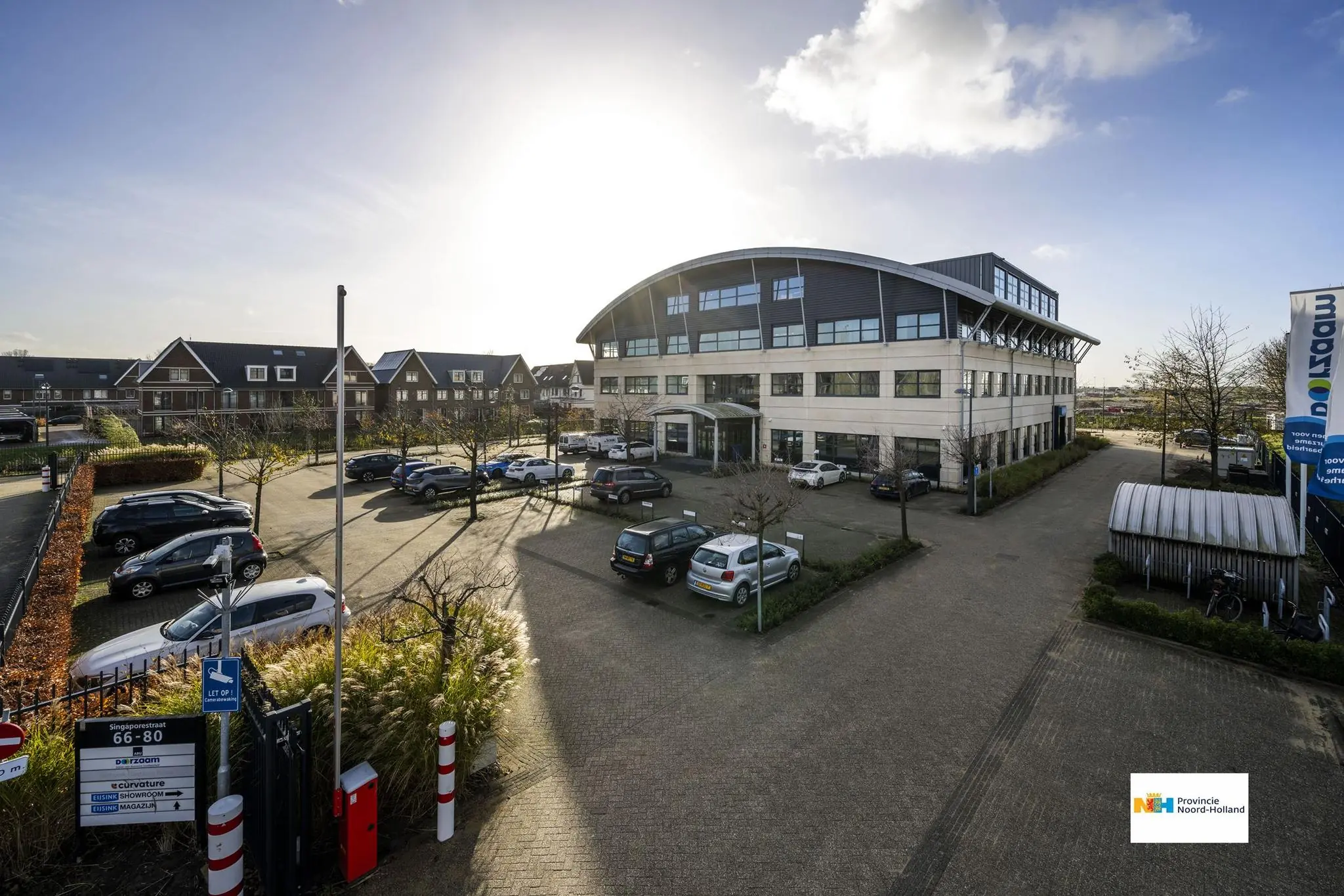 Kantoorpand aan de Singaporestraat in een zakelijke wijk met parkeerplaats en verschillende geparkeerde auto's.