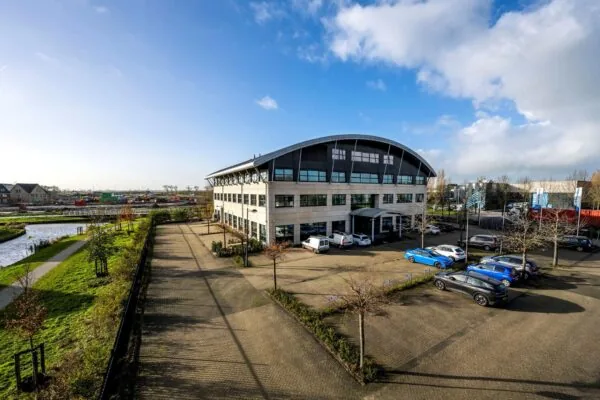 Modern kantoorgebouw aan de Singaporestraat met omliggende parkeerplaatsen en waterpartij op de voorgrond.