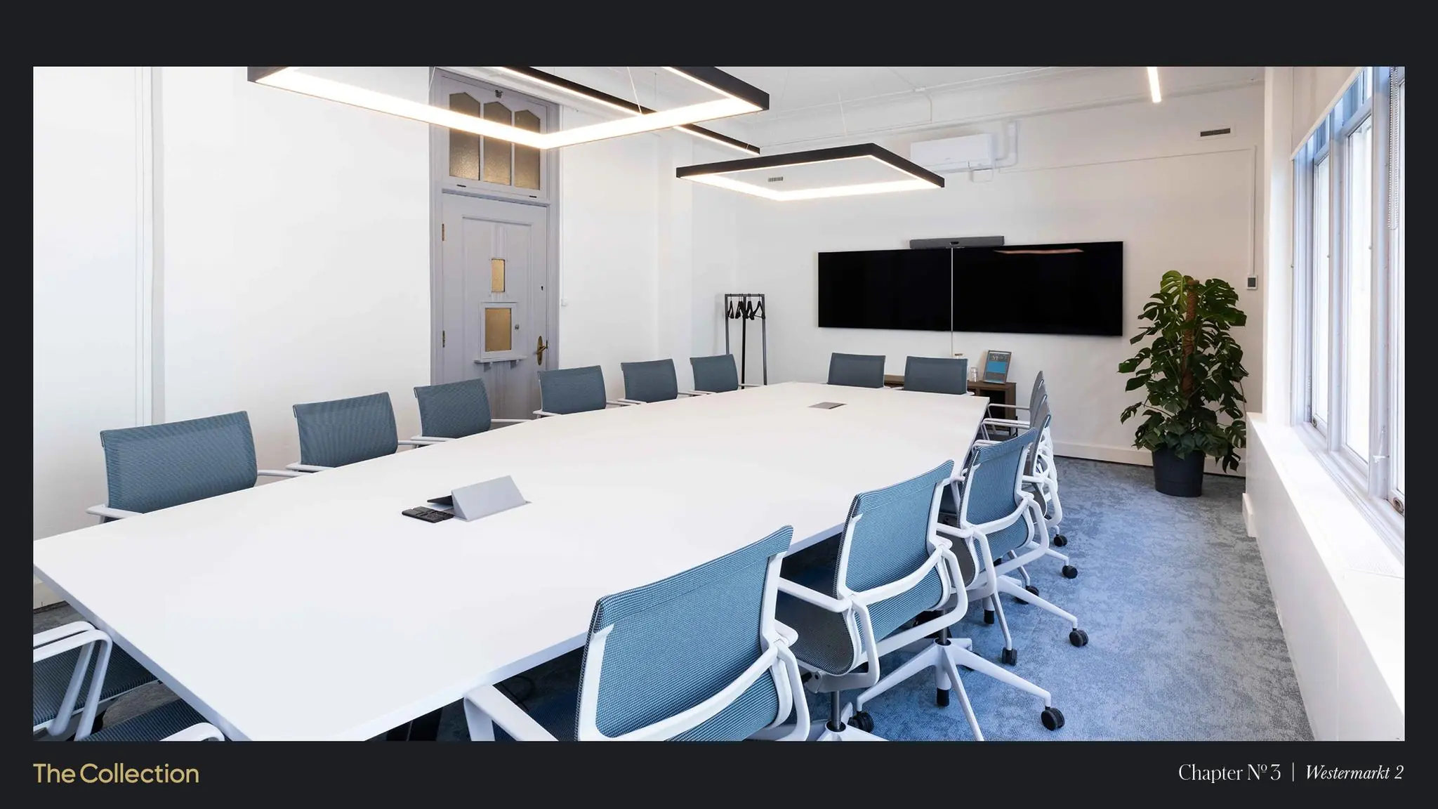Vergaderruimte met moderne inrichting, groot wit conferentietafel, blauwe stoelen, beeldscherm aan de muur en natuurlijk licht in Westermarkt 2.
