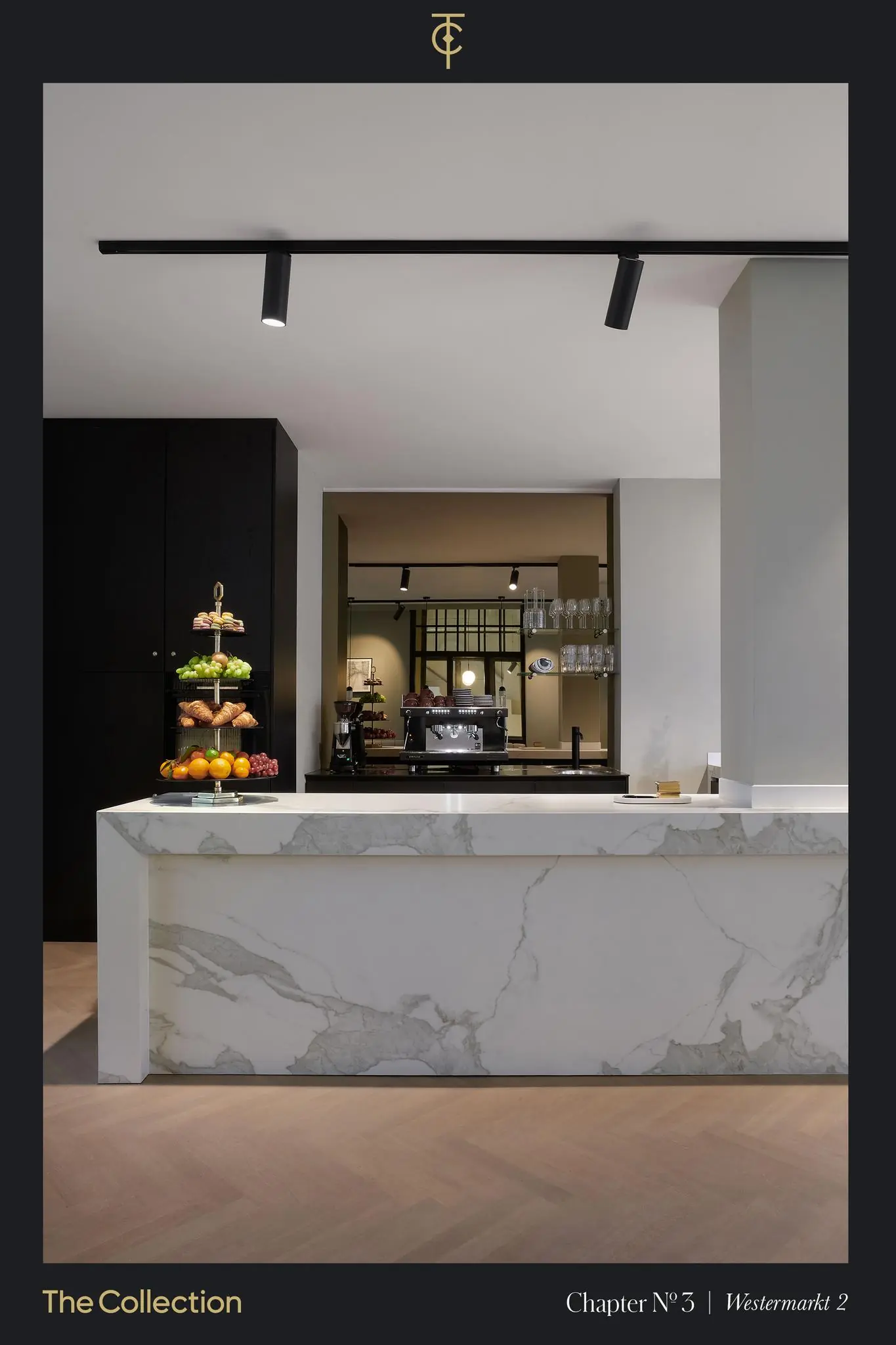 Moderne keuken met marmeren kookeiland en een etagère met vers fruit en gebak bij Westermarkt 2.