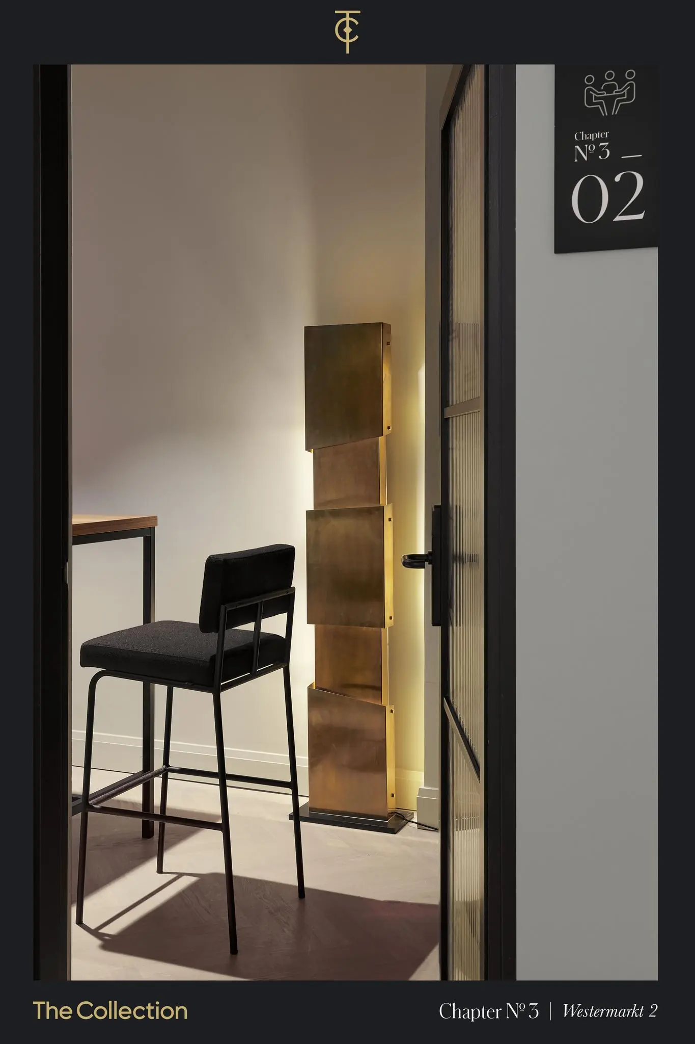 Moderne interieurhoek met een hoge zwarte stoel, een houten tafel en een sculpturale gouden staande lamp in Westermarkt 2.