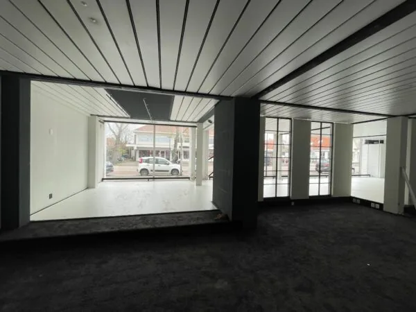 Leegstaand winkelpand aan de Ophelialaan met grote etalageruiten en zicht op de straat.