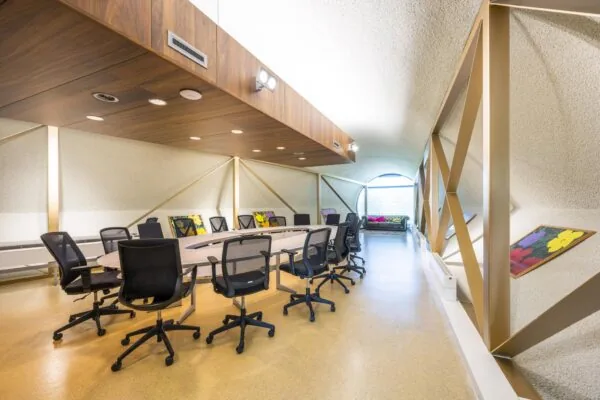Moderne vergaderruimte aan de Prof. W.H. Keesomlaan met ovale tafel, bureaustoelen, kunst aan de muren en een zithoek bij het raam.