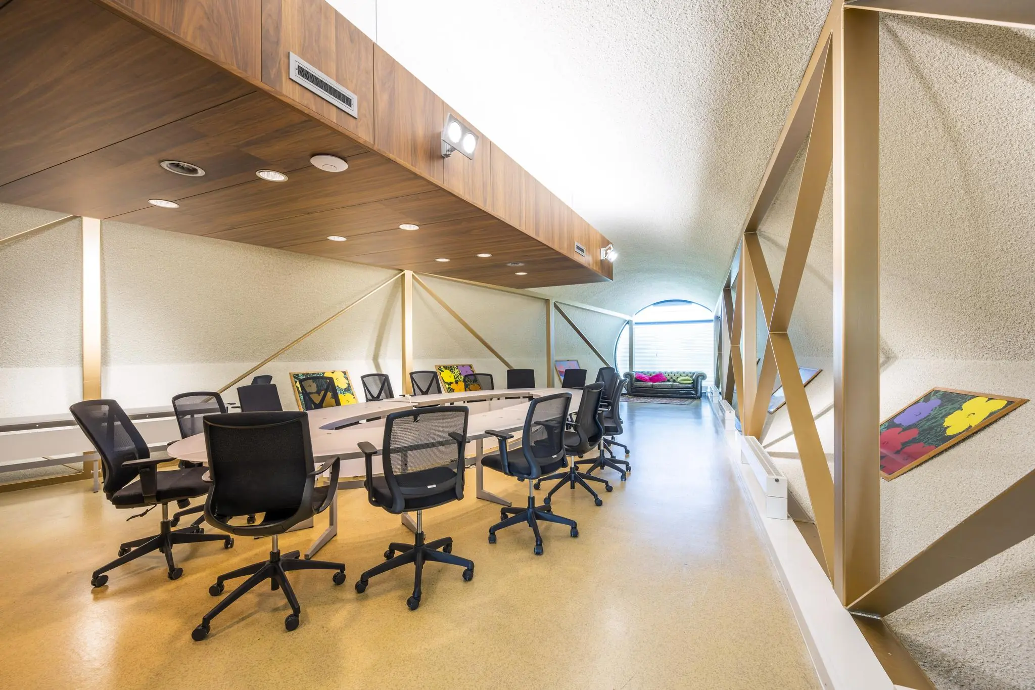 Moderne vergaderruimte aan de Prof. W.H. Keesomlaan met ovale tafel, bureaustoelen, kunst aan de muren en een zithoek bij het raam.