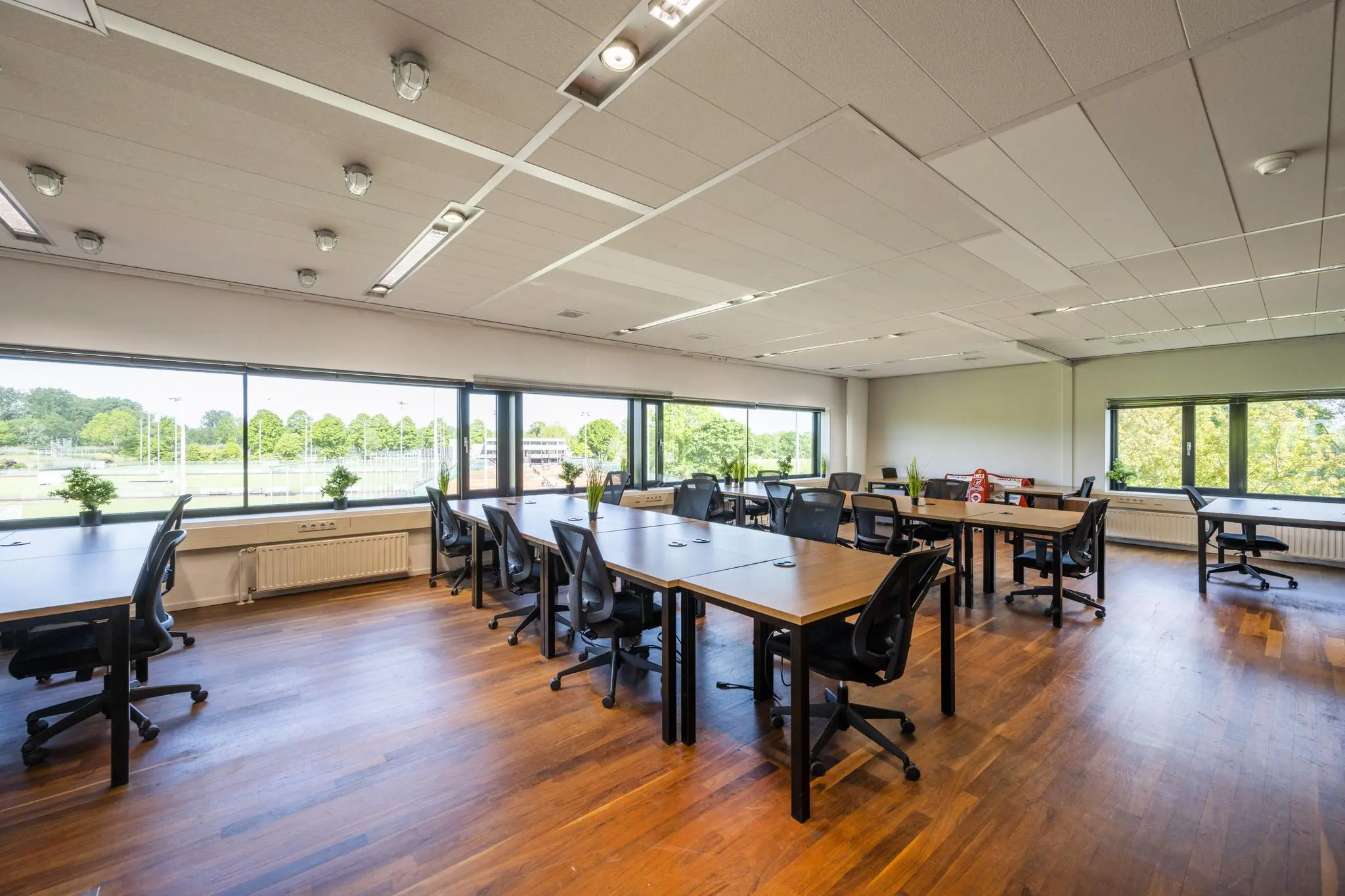Ruime en lichte kantoortuin met moderne bureaus en stoelen aan de Prof. W.H. Keesomlaan.