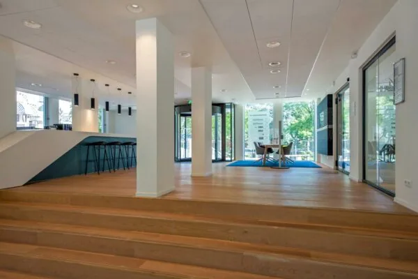 Moderne, open kantoorruimte aan de Bezuidenhoutseweg met een zithoek, balie en glazen entreedeuren.