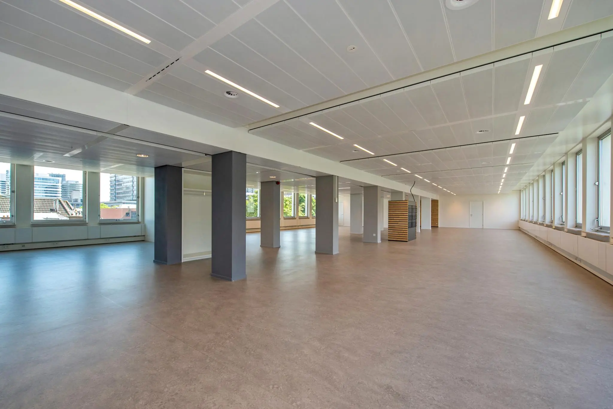 Ruim en licht kantoorinterieur aan de Bezuidenhoutseweg met grote ramen en moderne afwerking.