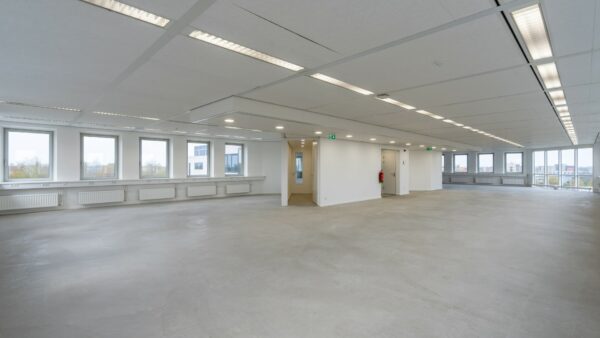 Leeg en licht kantoorpand aan de Printerweg met grote ramen en systeemplafond.