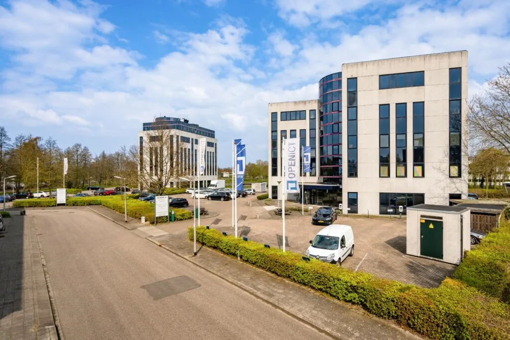 Kantoorpanden aan de Printerweg in Amersfoort met parkeerterrein en vlaggen van OpenICT.