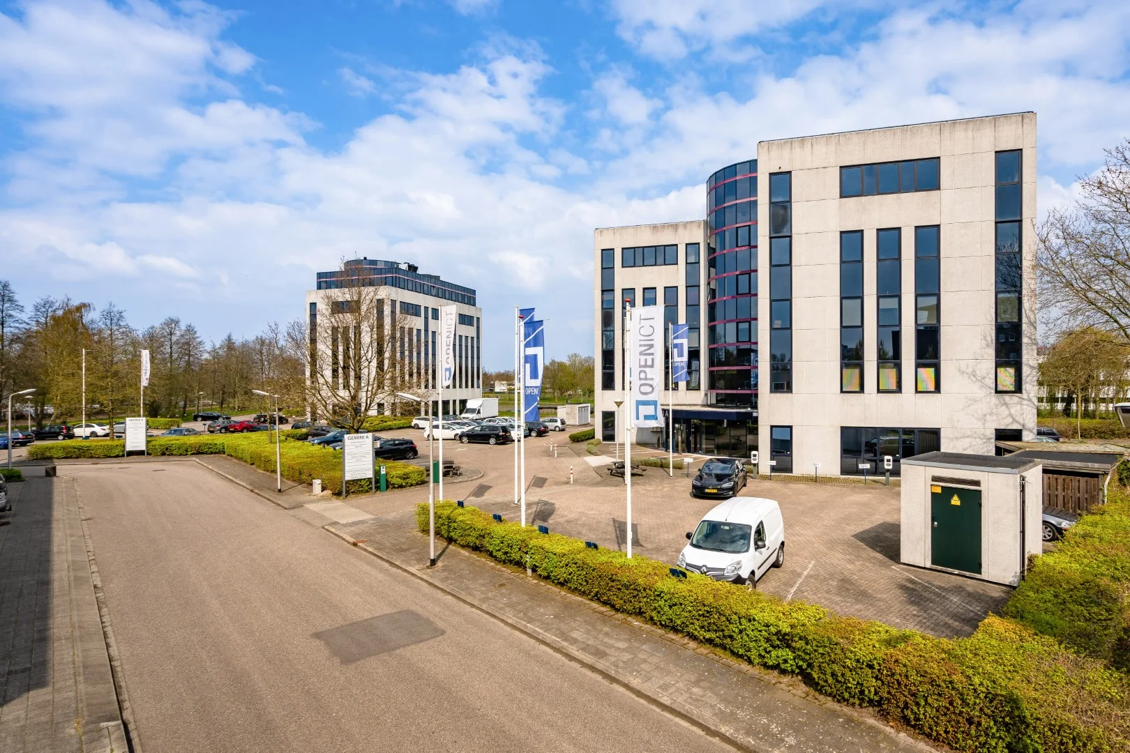 Kantoorpanden aan de Printerweg in Amersfoort met parkeerterrein en vlaggen van OpenICT.