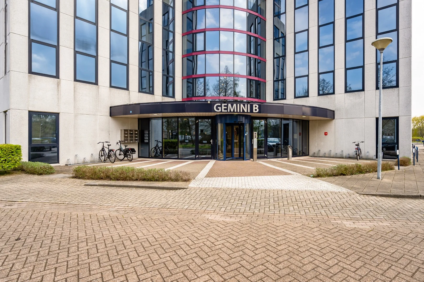 Vooraanzicht van kantoorgebouw Gemini B aan de Printerweg met fietsenrekken en hoofdingang.