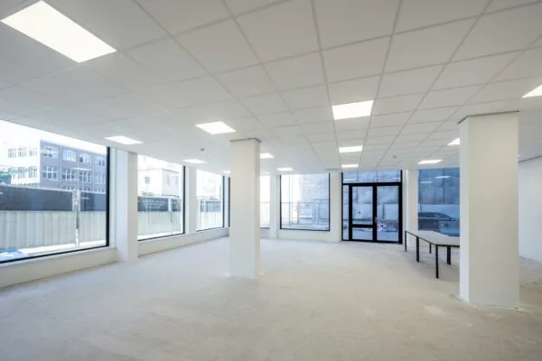 Lichte, lege kantoorruimte aan de Oostenburgermiddenstraat met grote ramen en systeemplafond.