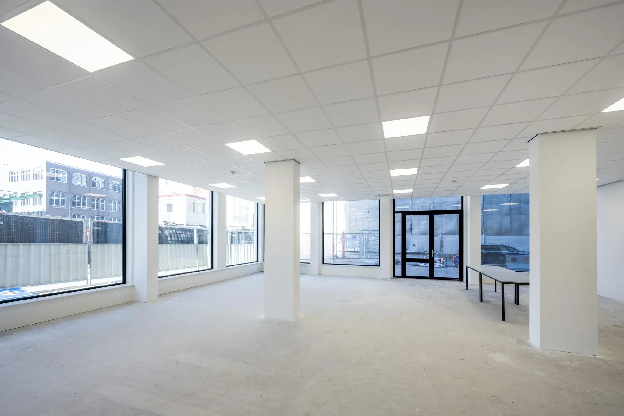 Lichte, lege kantoorruimte aan de Oostenburgermiddenstraat met grote ramen en systeemplafond.