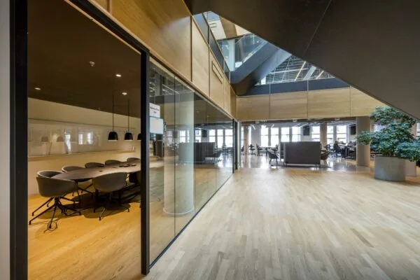 Modern kantoorinterieur aan het Rokin met vergaderruimte, open werkplekken en houten vloer.