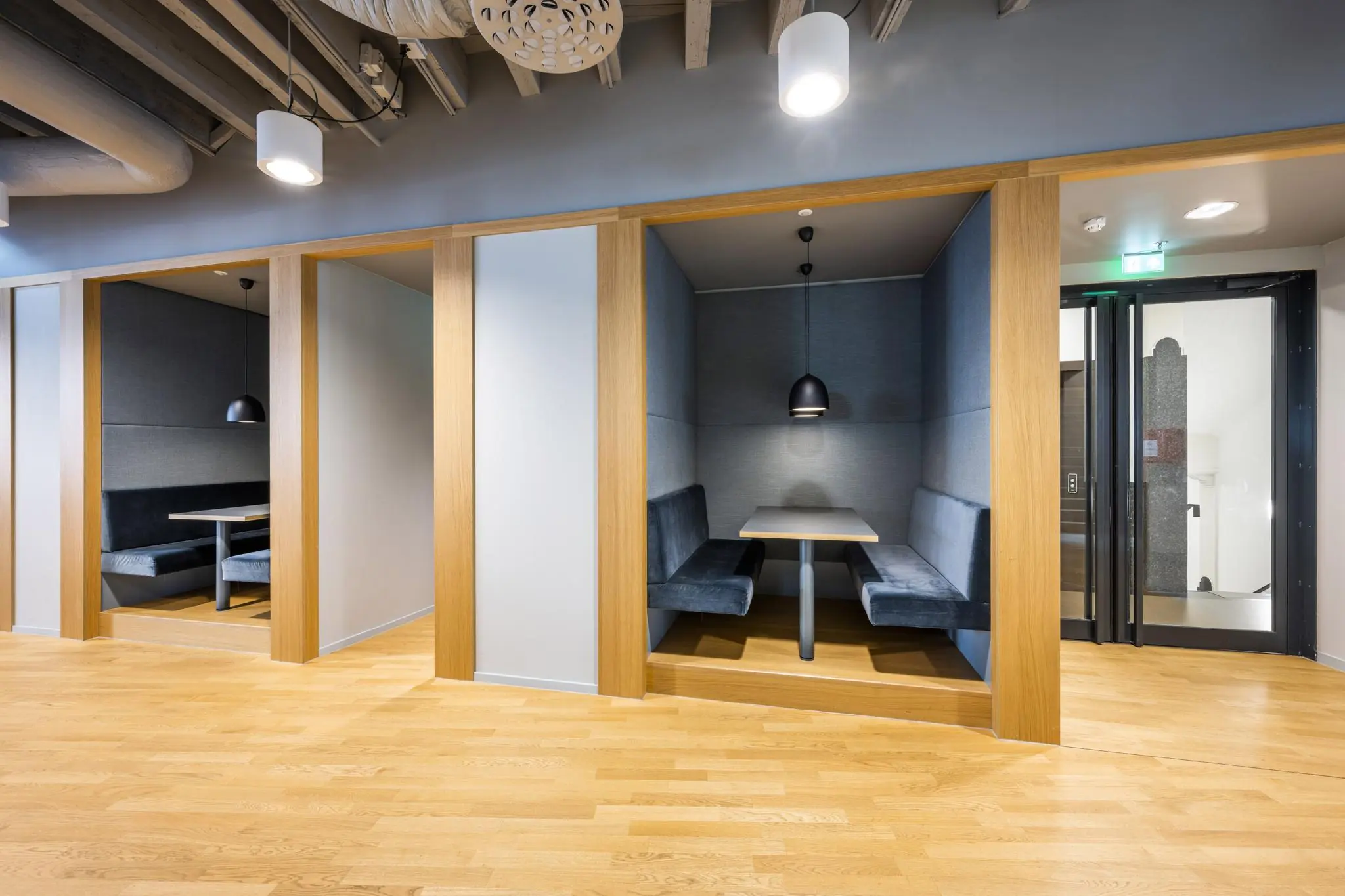 Moderne kantoorruimte aan het Rokin met ingebouwde zitnissen en houten afwerking.