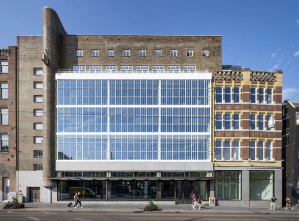 Vooraanzicht van een modernistisch kantoorgebouw aan het Rokin in Amsterdam met grote glazen gevel en omringende historische panden.