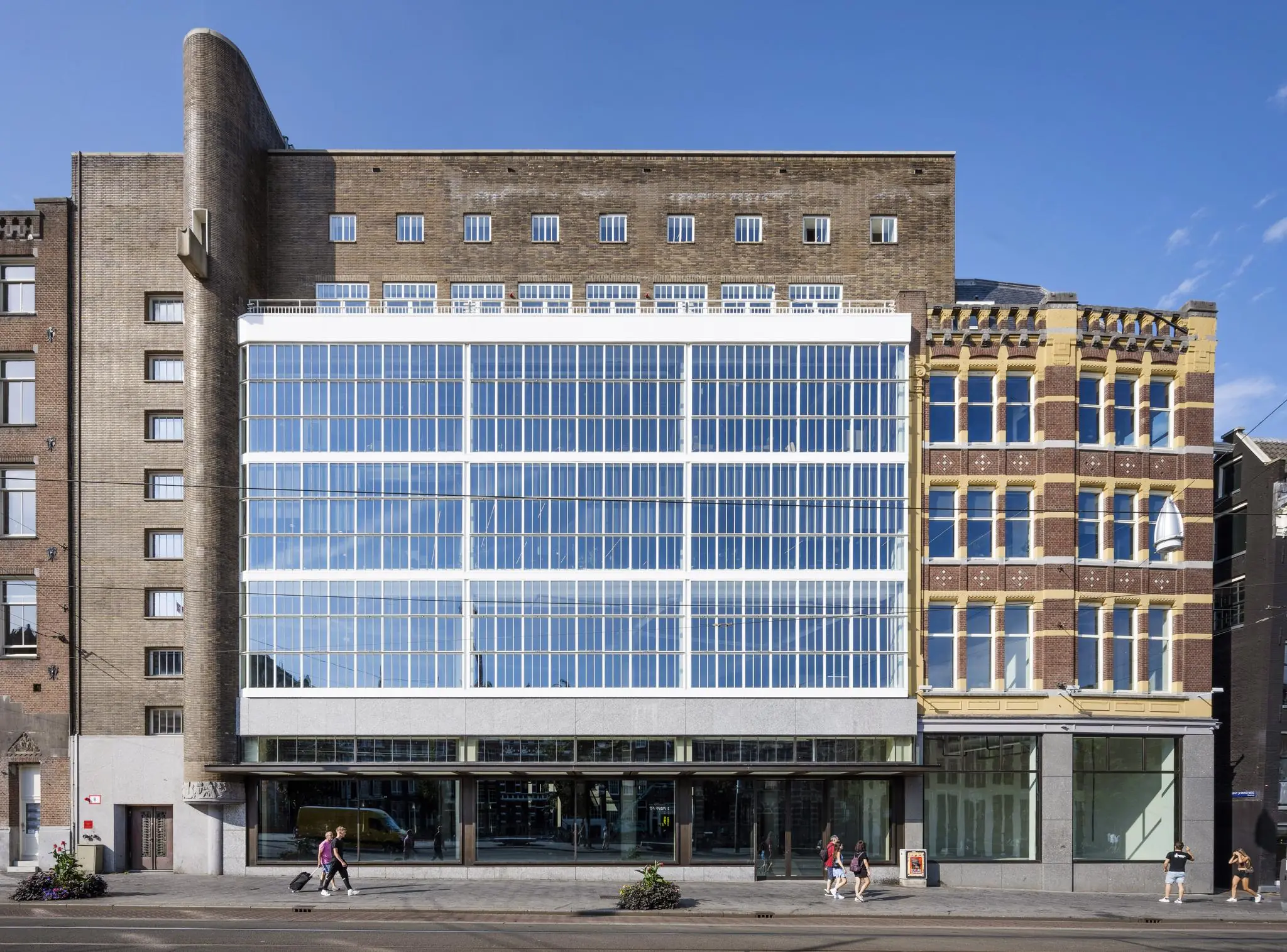Vooraanzicht van een modernistisch kantoorgebouw aan het Rokin in Amsterdam met grote glazen gevel en omringende historische panden.