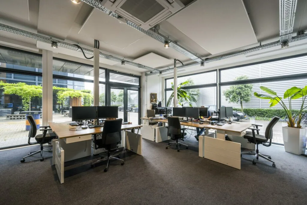 Modern kantoorinterieur aan de Asterweg met flexplekken, grote ramen en veel daglicht.
