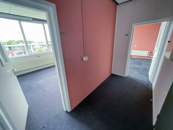 Gang in een kantoorpand aan de Hengeveldstraat met open deuren naar twee ruime, lichtovergoten kamers.