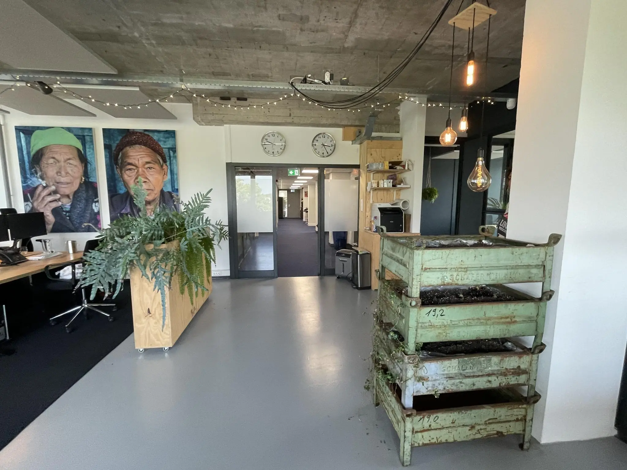 Een creatieve kantoorruimte aan de Hengeveldstraat met planten, kunstwerken aan de muur en industriële decoratie.