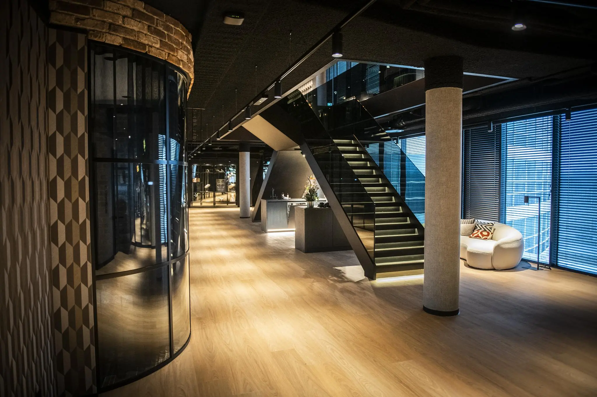 Moderne kantoorruimte in Stationspark met houten vloer, designtrap en glazen wanden.