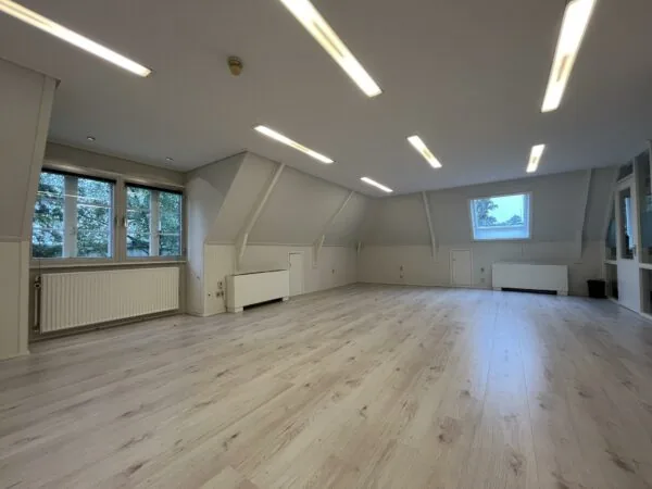 Lichte, ruime zolderkamer aan de Amersfoortsestraat met houten vloer, inbouwverlichting en grote ramen.