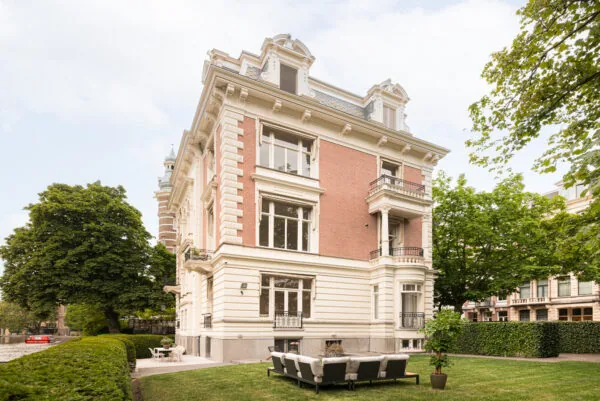 Statig herenhuis aan de Weteringschans met klassieke gevel en groene tuin aan het water.