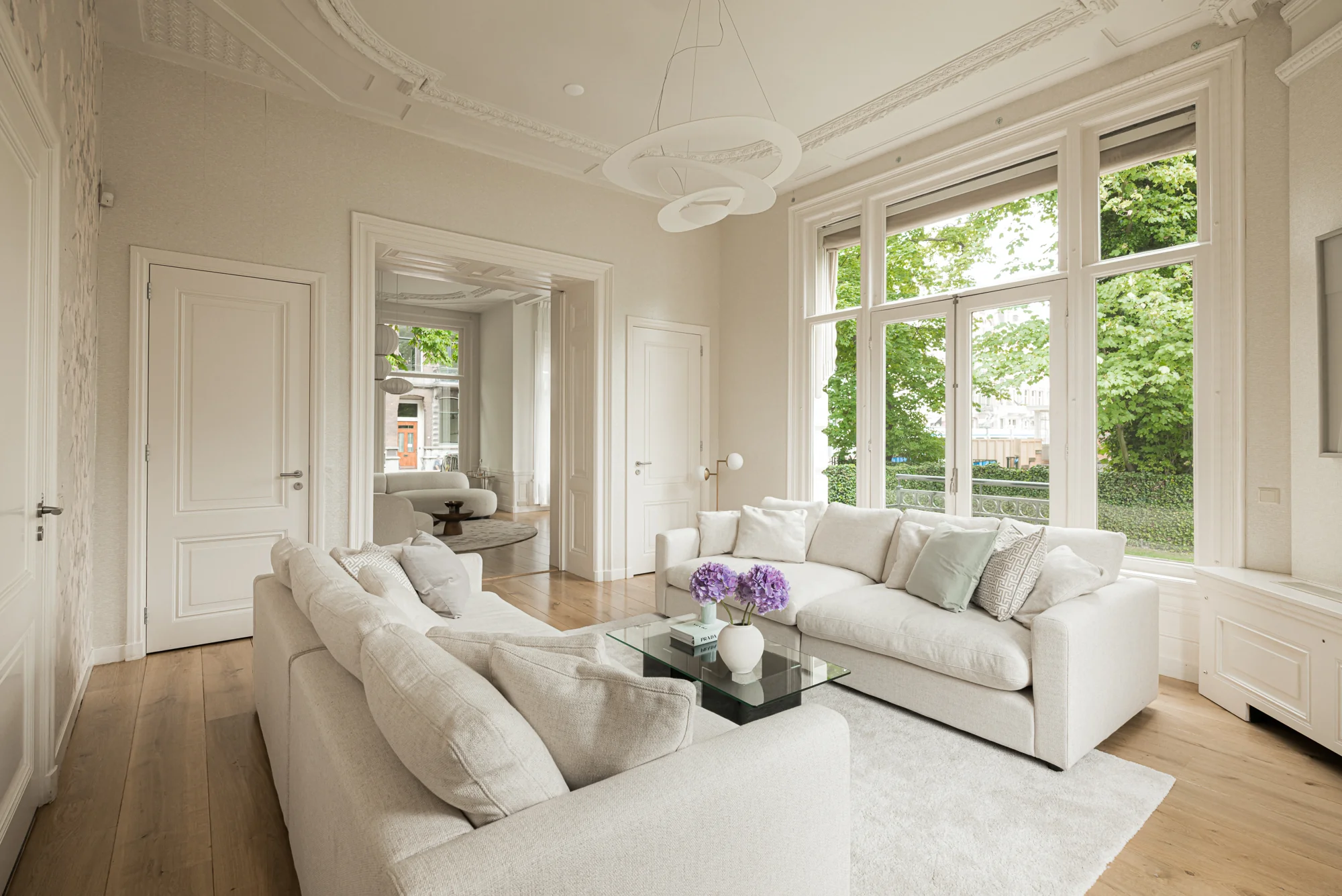 Licht en elegant ingericht woonhuis aan de Weteringschans met moderne zithoek en grote ramen met uitzicht op het groen.