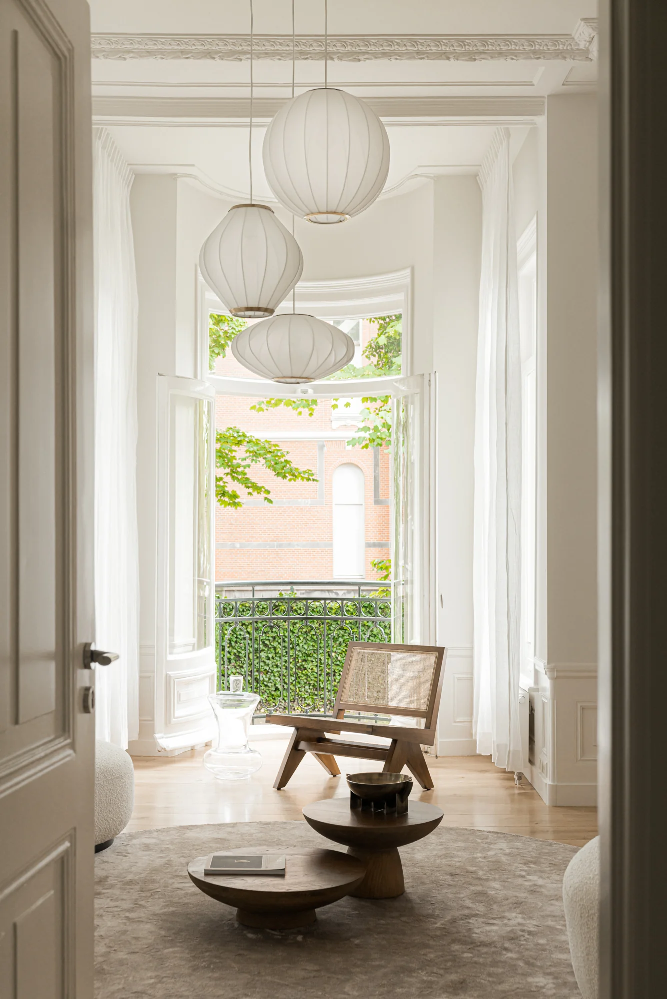 Licht en elegant interieur aan de Weteringschans met houten meubels, hoge plafonds en openslaande deuren naar een balkon.