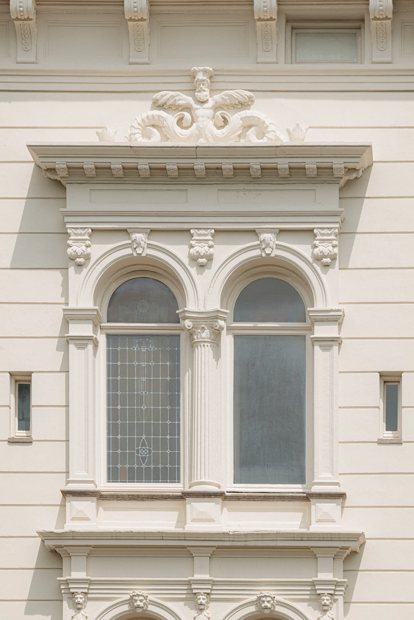Een rijk gedecoreerd, klassiek venster met boogramen en ornamenten aan de gevel van een pand aan de Weteringschans.