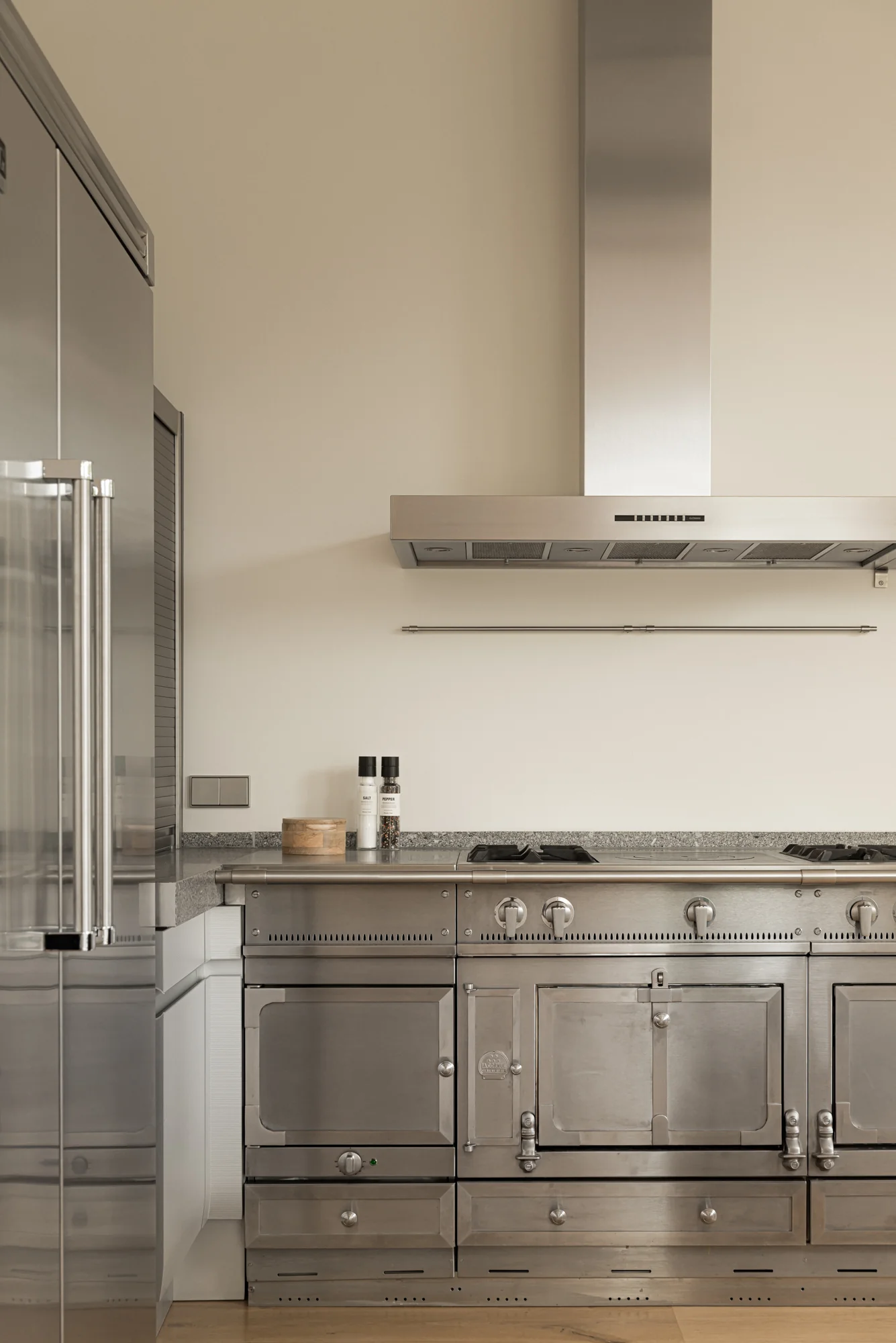 Moderne keuken met een groot roestvrijstalen fornuis, afzuigkap en ingebouwde koelkast aan de Weteringschans.