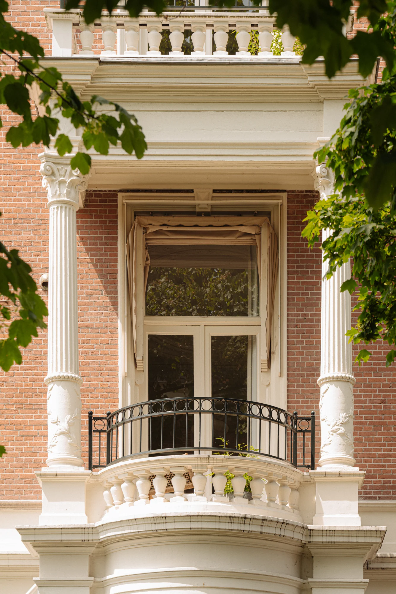 Balkon met smeedijzeren hekwerk en zuilen aan een klassiek pand aan de Weteringschans.
