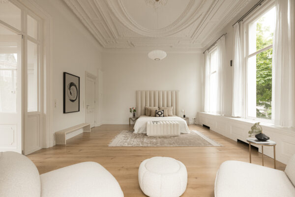 Luxe, licht ingerichte slaapkamer aan de Weteringschans met hoge plafonds en grote ramen.