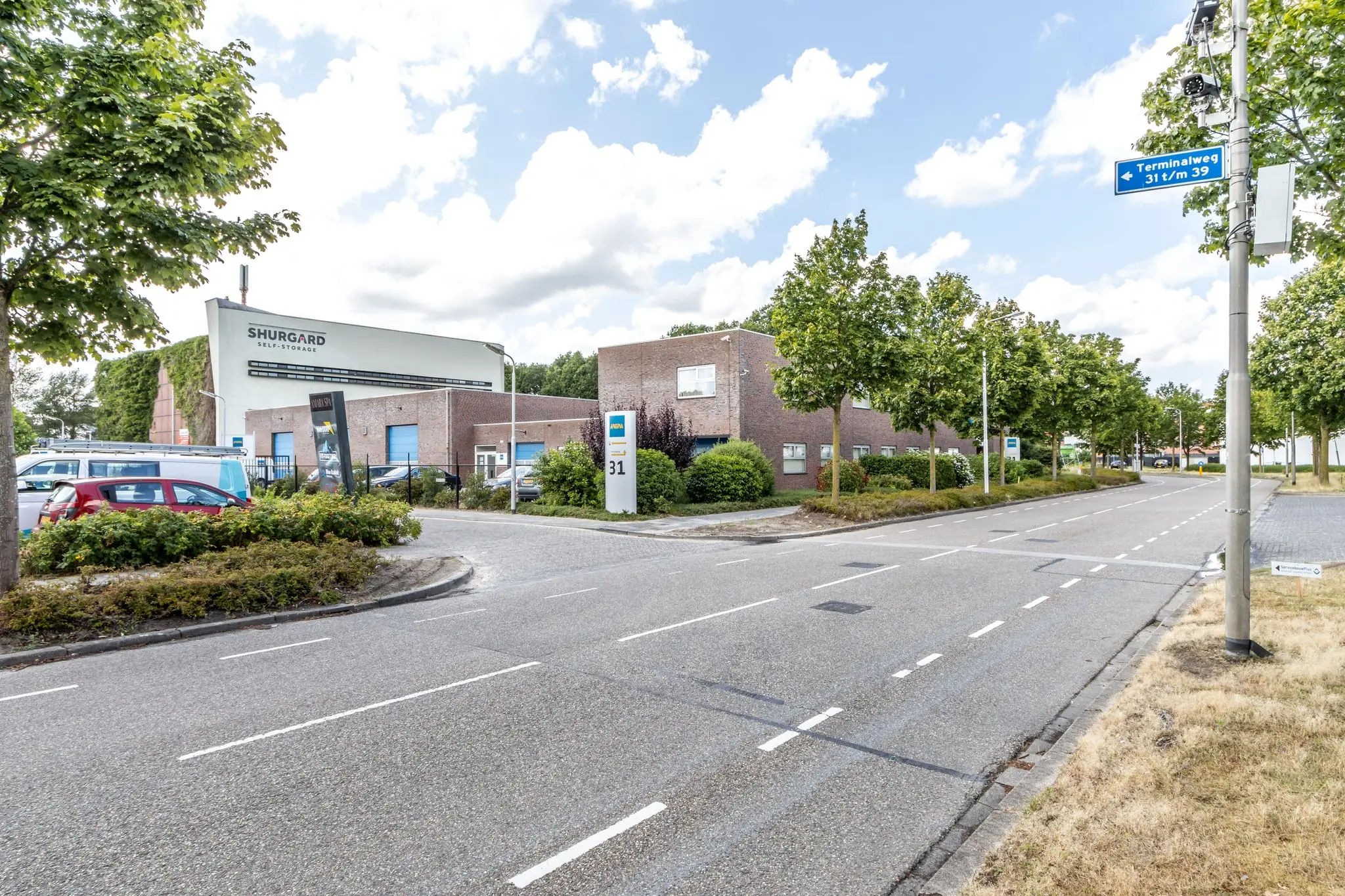 Straatbeeld van de Terminalweg met het Shurgard Self-Storage gebouw en meerdere bedrijfsgebouwen aan de overzijde.