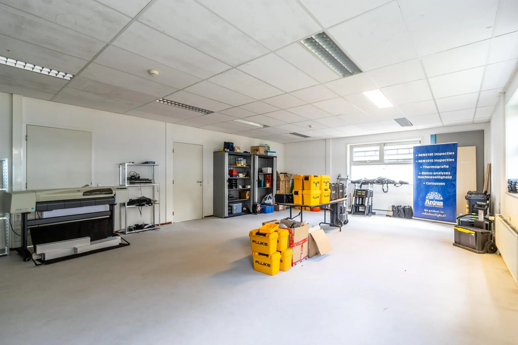 Lichte werkruimte aan de Terminalweg met meetapparatuur, opslagkasten en een banner van inspectiebedrijf Argus.