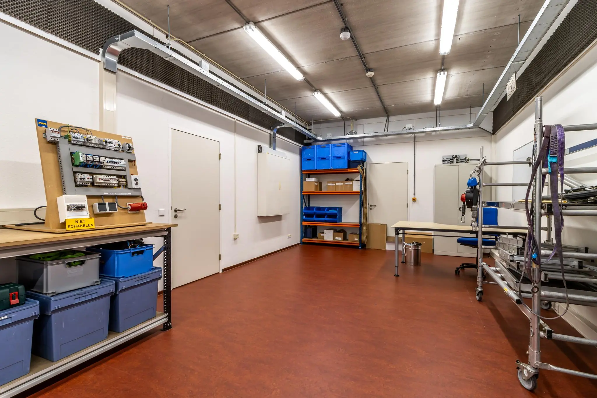 Opgeruimde technische werkruimte aan de Terminalweg met opbergkasten, werkbanken en elektriciteitsdemonstratiepaneel.
