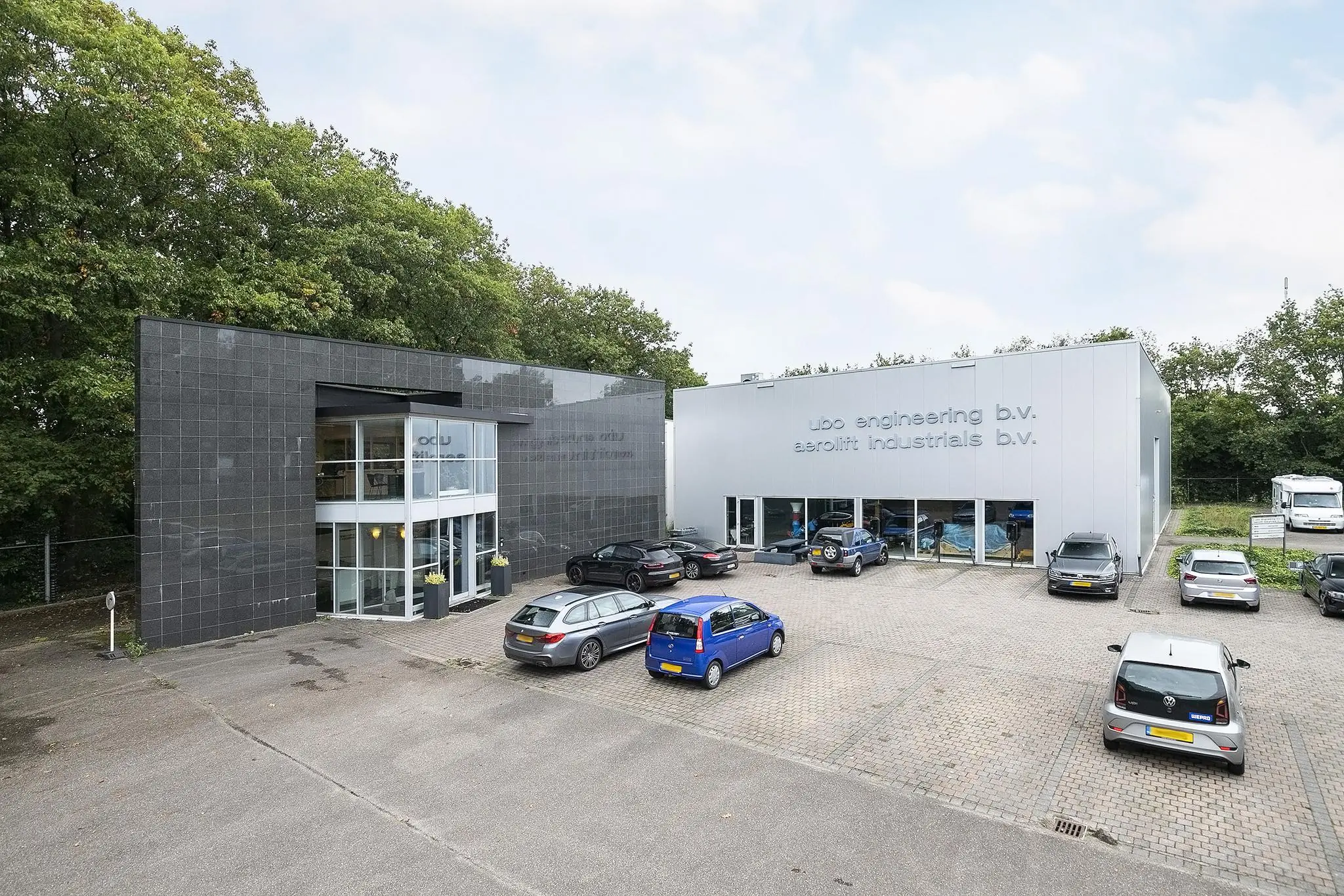 Bedrijfsgebouw aan de Banningstraat met geparkeerde auto's voor de ingangen van ubo engineering b.v. en aerolift industrials b.v.