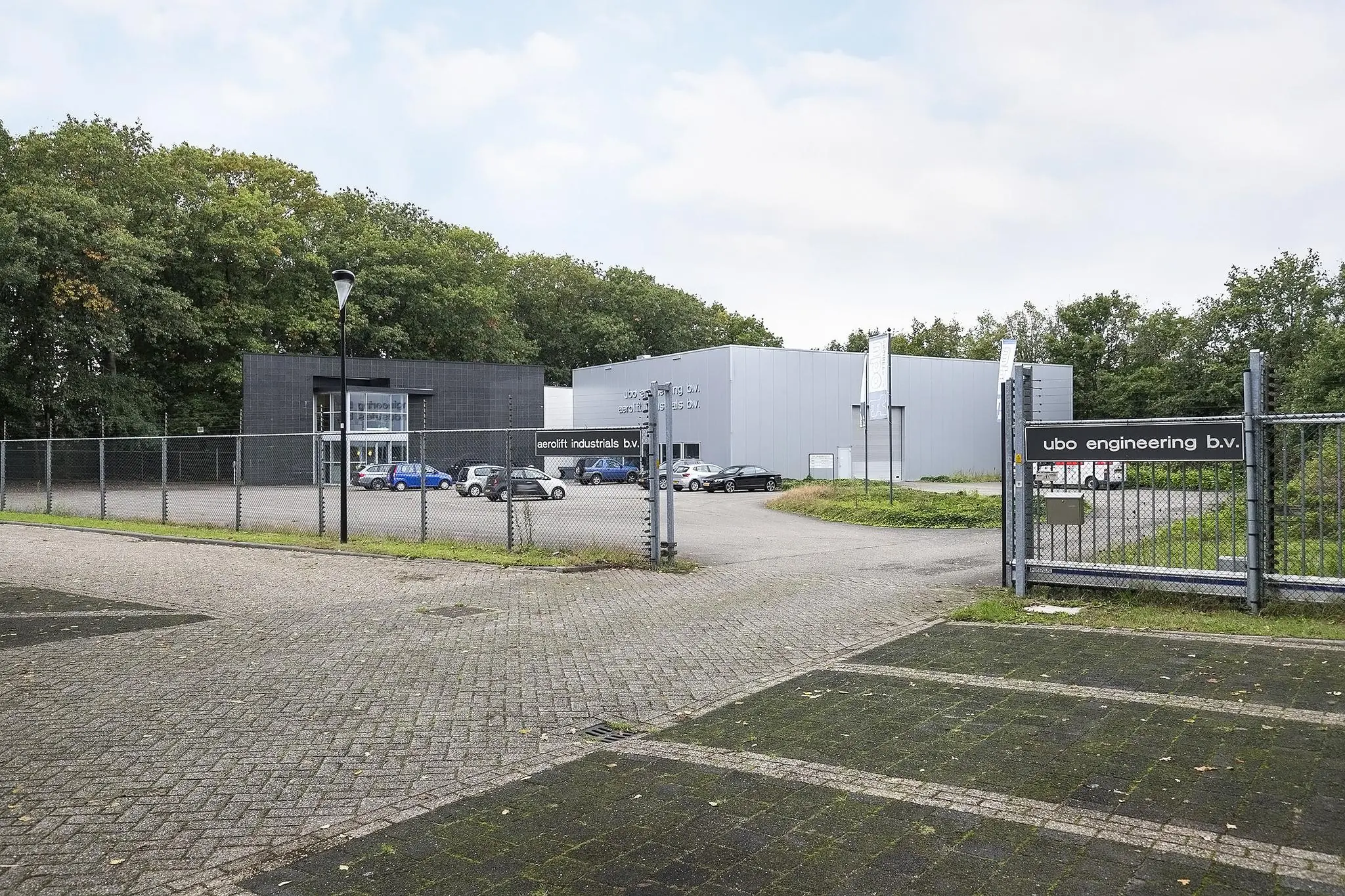 Bedrijventerrein met de panden van UBO Engineering B.V. en Aerolift Industrials B.V. aan de Banningstraat, omgeven door een hek en parkeerplaatsen.