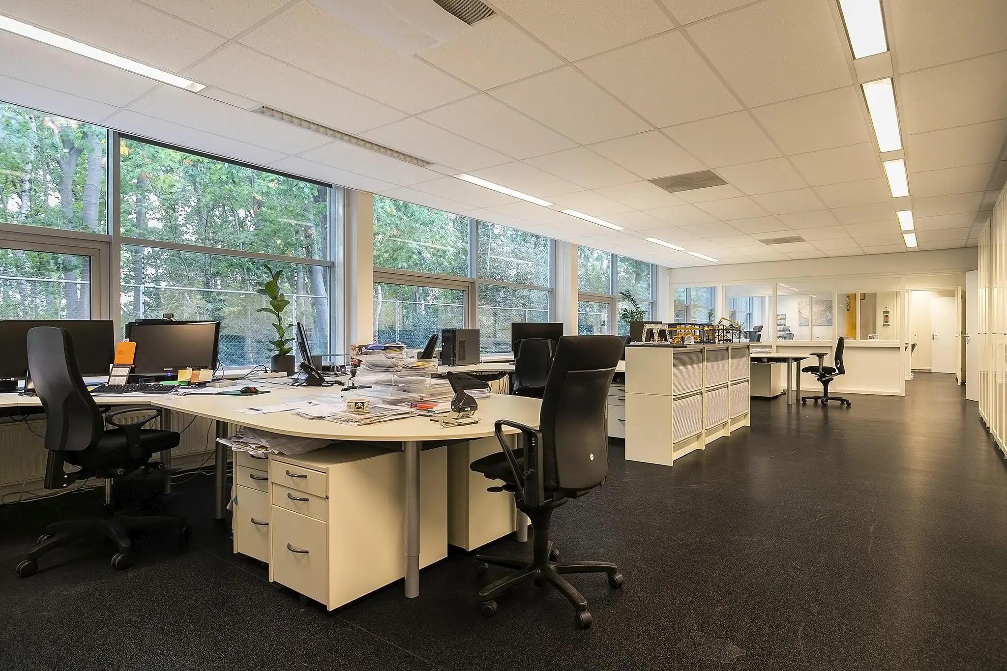 Ruim en licht kantoor aan de Banningstraat met meerdere werkplekken, grote ramen en moderne kantoormeubelen.