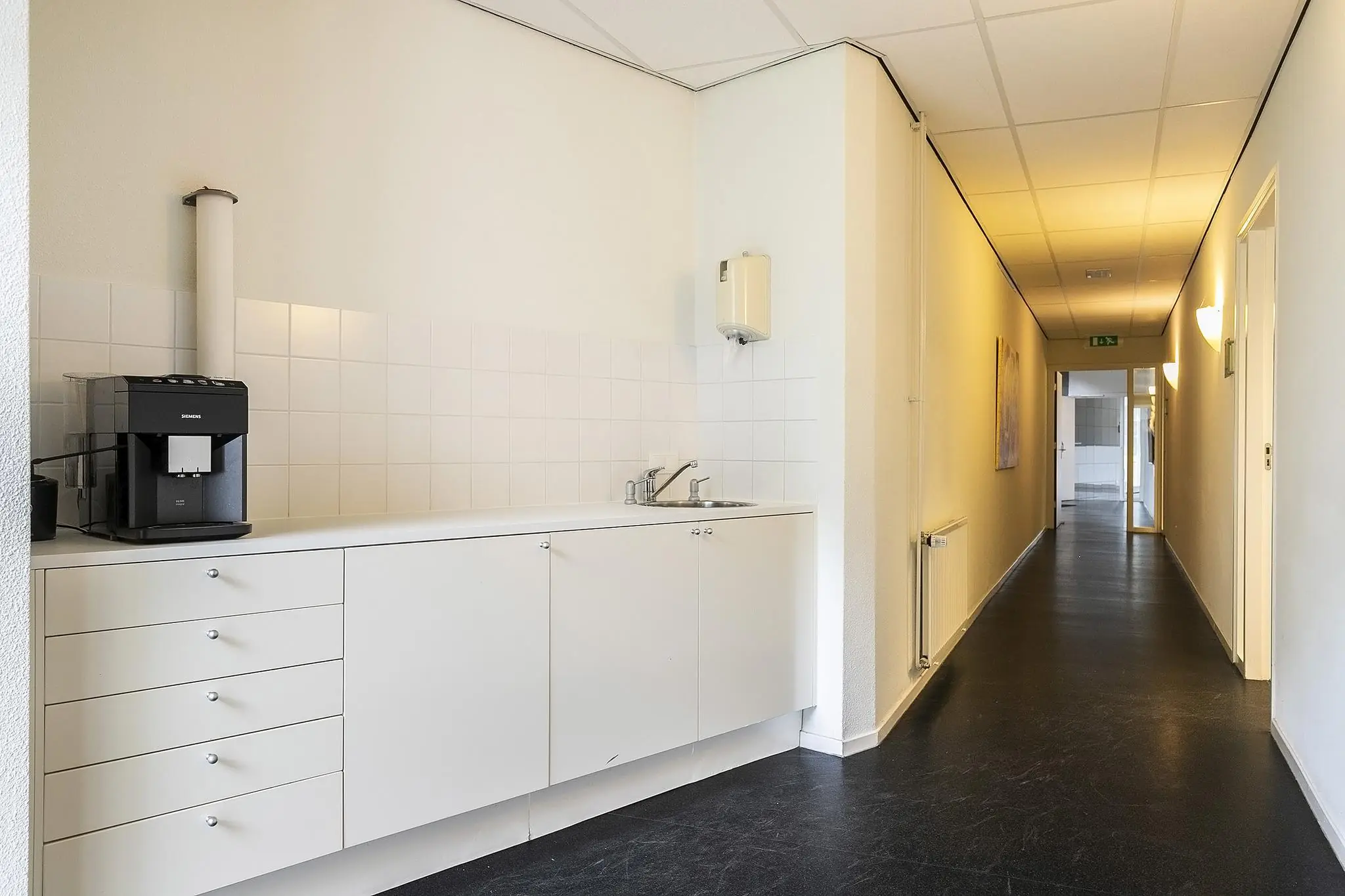 Kleine pantry met koffiezetapparaat in een lichte gang aan de Banningstraat.