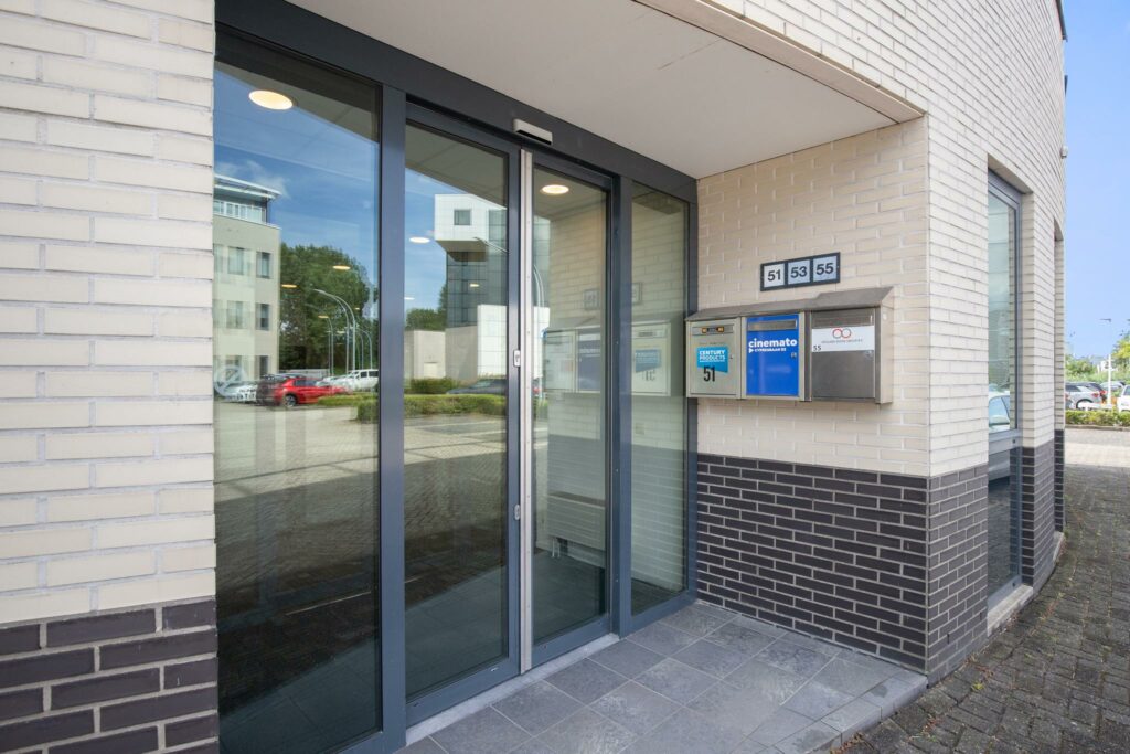Glazen entree van een kantoorpand aan de Cypresbaan met brievenbussen voor de nummers 51, 53 en 55.