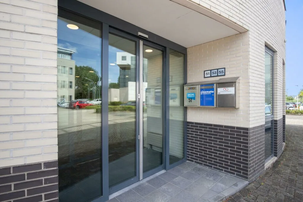 Glazen entree van een kantoorpand aan de Cypresbaan met brievenbussen voor de nummers 51, 53 en 55.