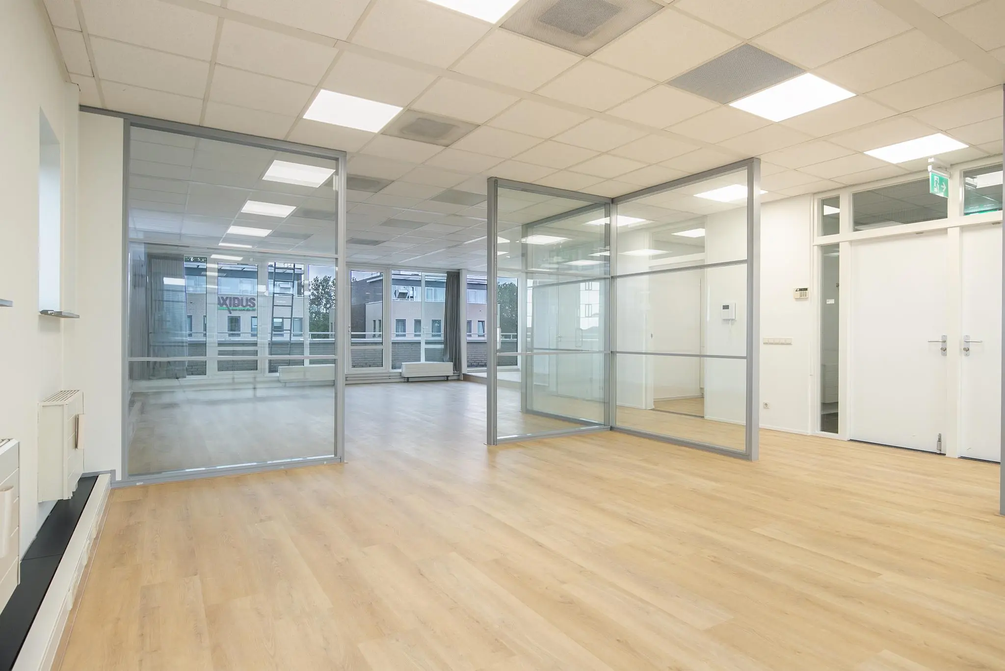 Moderne, lichte kantoorruimte aan de Cypresbaan met glazen scheidingswanden en houten vloer.