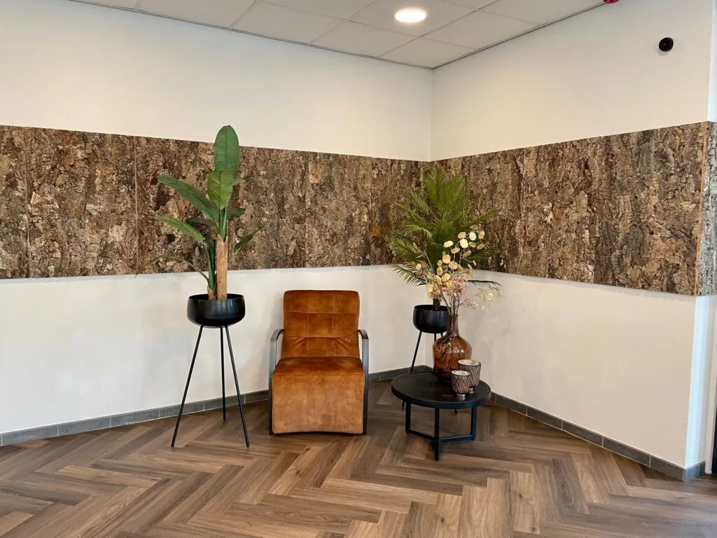 Zitruimte aan de Cypresbaan met een bruine fauteuil, planten en decoratieve houten wandpanelen.