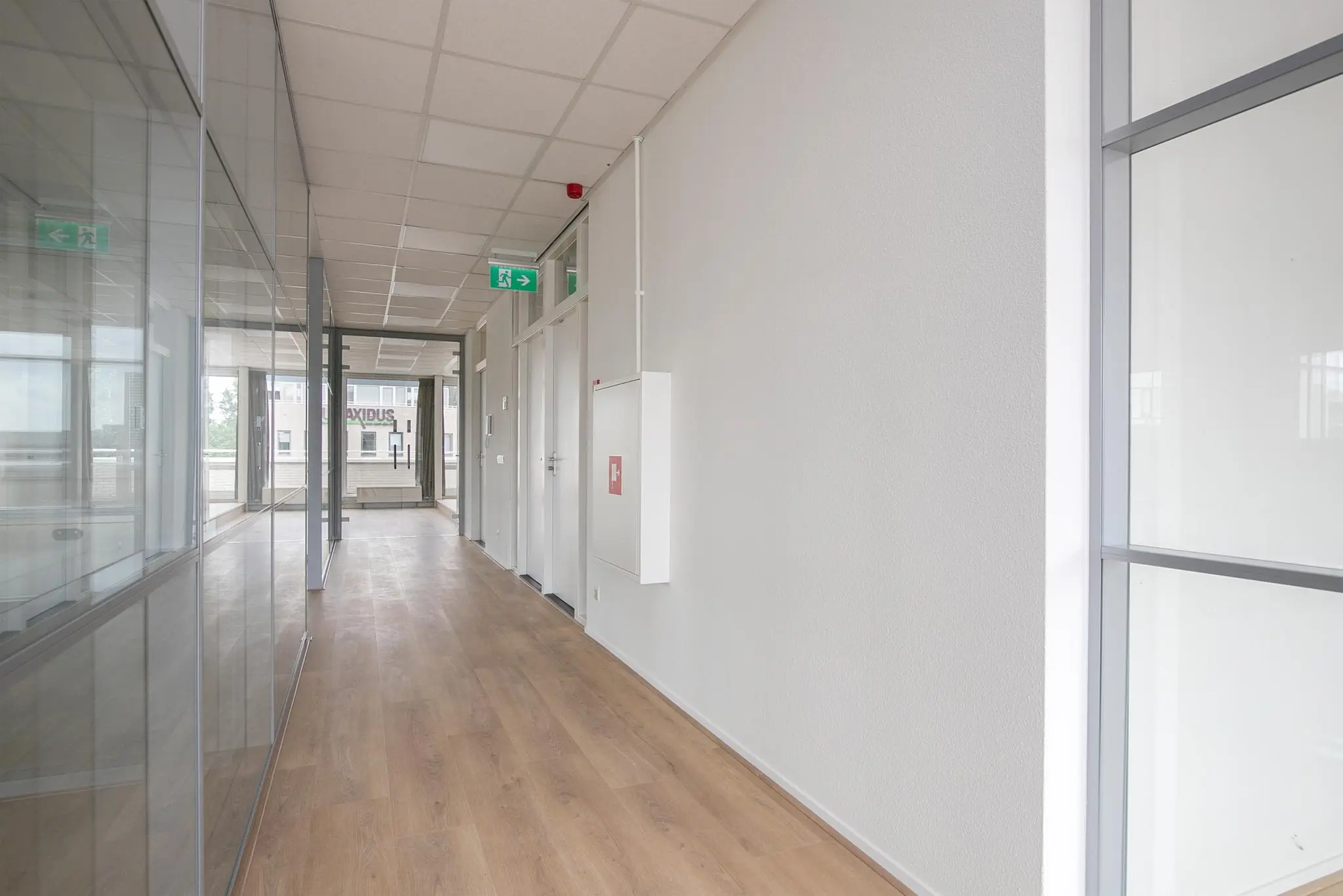 Licht kantoorinterieur met glazen wanden en houten vloer aan de Cypresbaan.