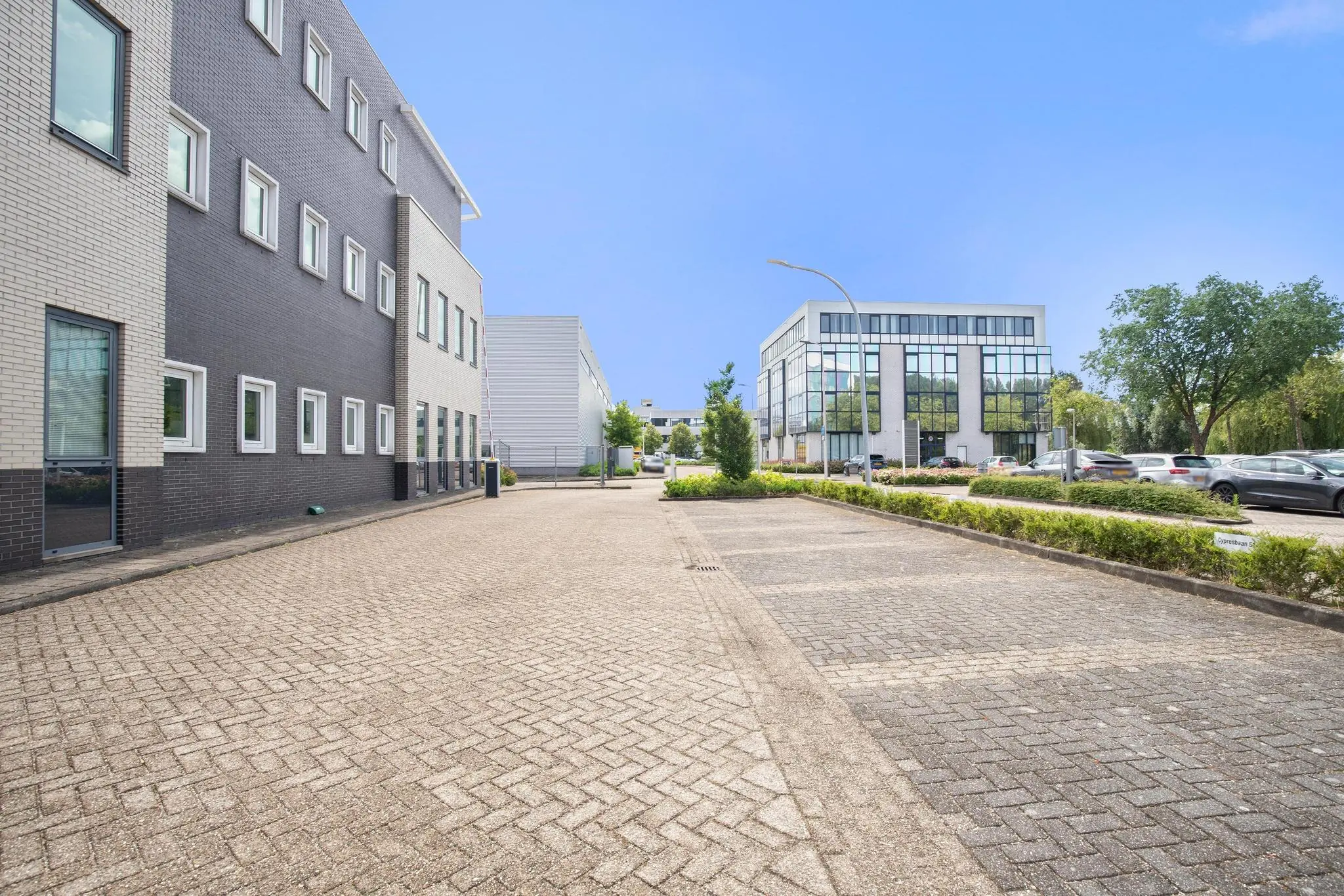 Verzorgd bedrijventerrein aan de Cypresbaan met moderne kantoorpanden en parkeerplaatsen.