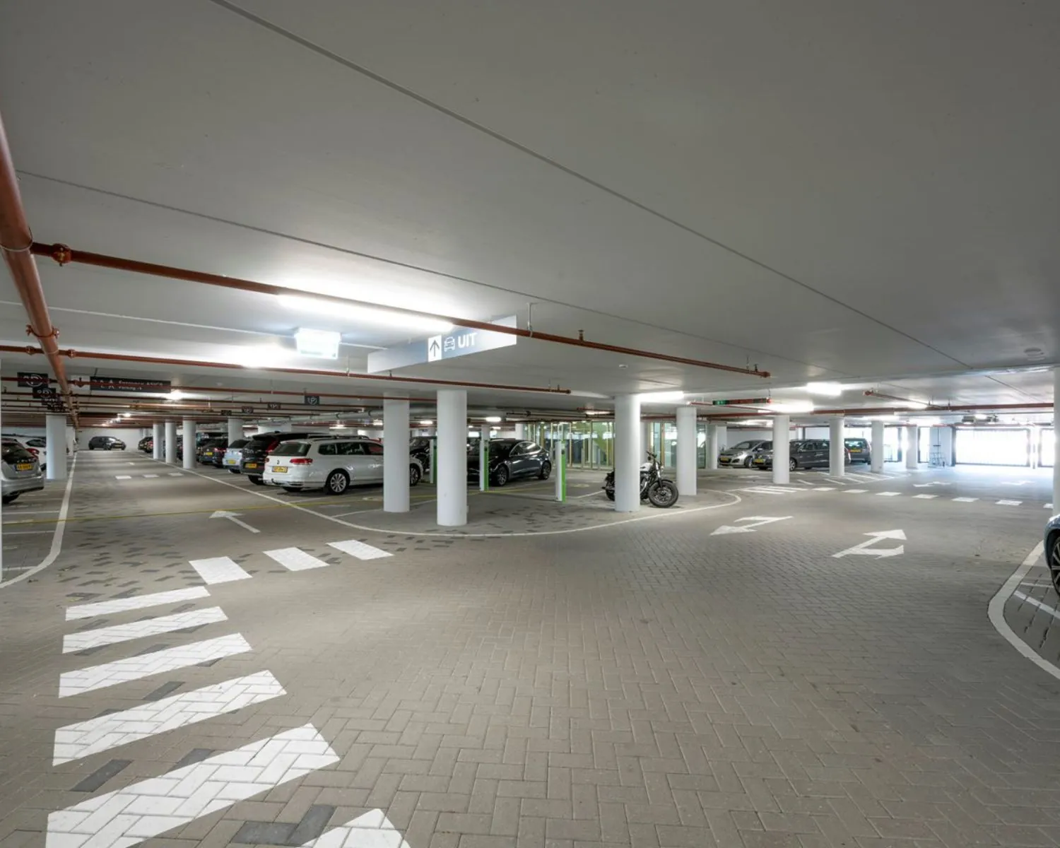 Overdekte parkeergarage bij kantoorruimte aan de Taurusavenue 165 in Hoofddorp met meerdere geparkeerde auto's en duidelijke bewegwijzering.