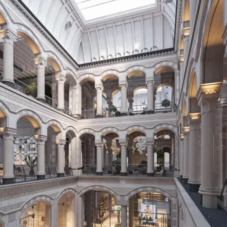 Licht atrium met meerdere etages en ronde bogen in het gebouw aan de Nieuwezijds Voorburgwal.