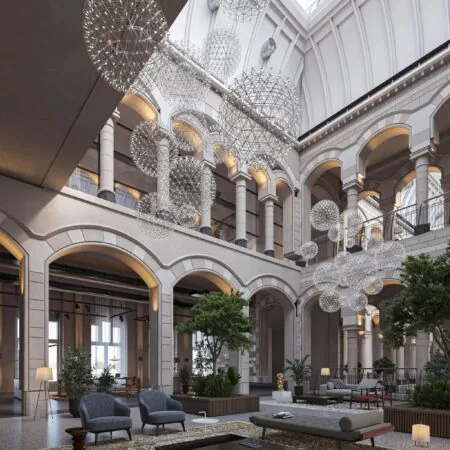 Luxe, modern ingerichte binnentuin met hoge plafonds en glazen koepel in een historisch pand aan de Nieuwezijds Voorburgwal.